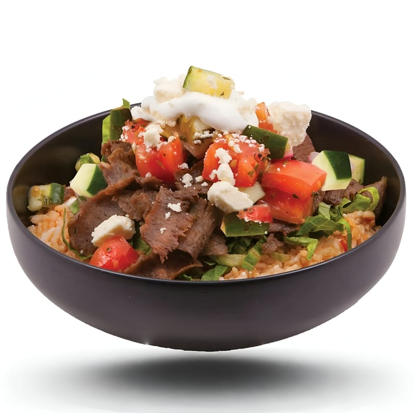 Gyro Wrap bowl with sliced meat, rice, tomatoes, cucumbers, feta cheese, and white sauce.