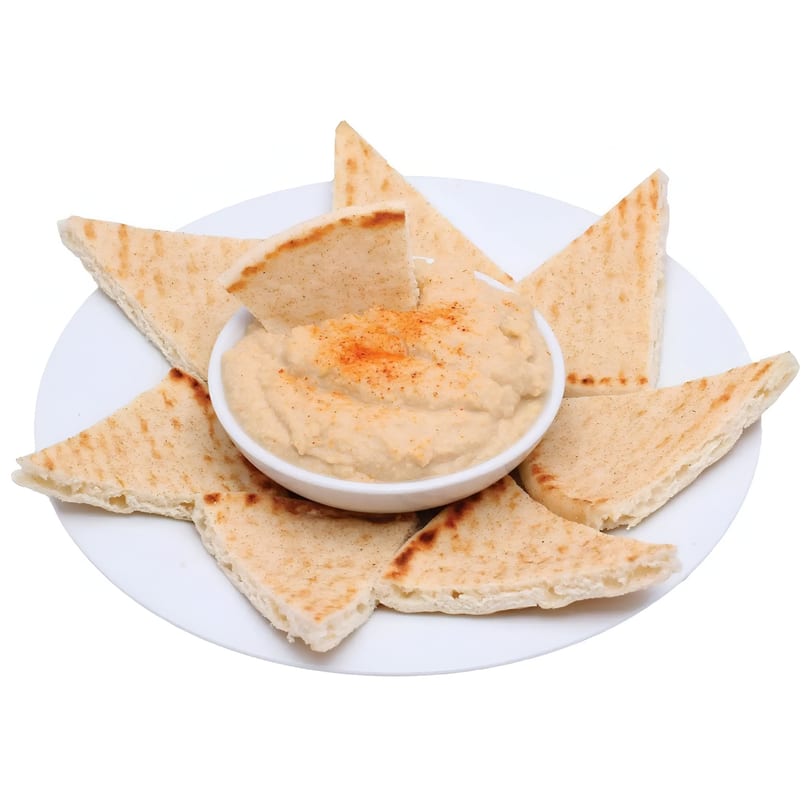 Hummus topped with paprika, surrounded by triangular pita bread pieces on a white plate.